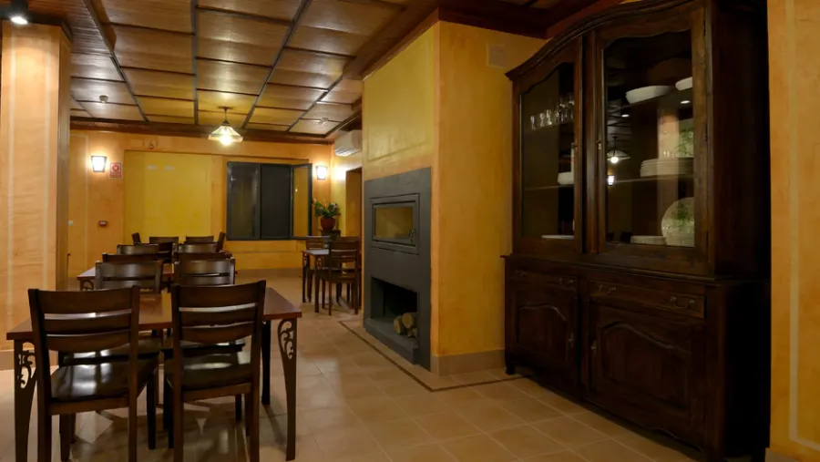 Sala de seminarios con mesas de trabajo y chimenea
